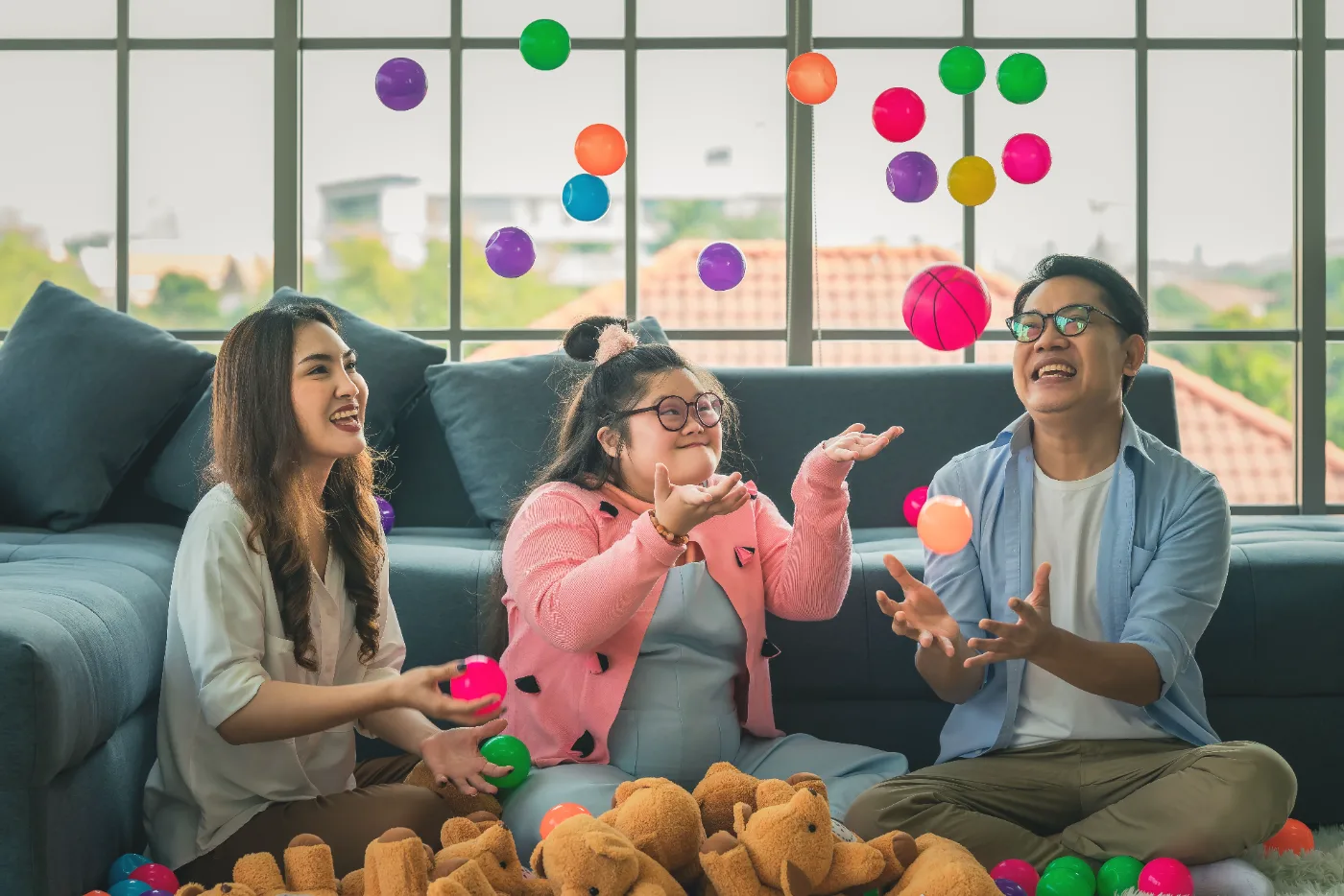 A family playing with balls together at home with their daughter