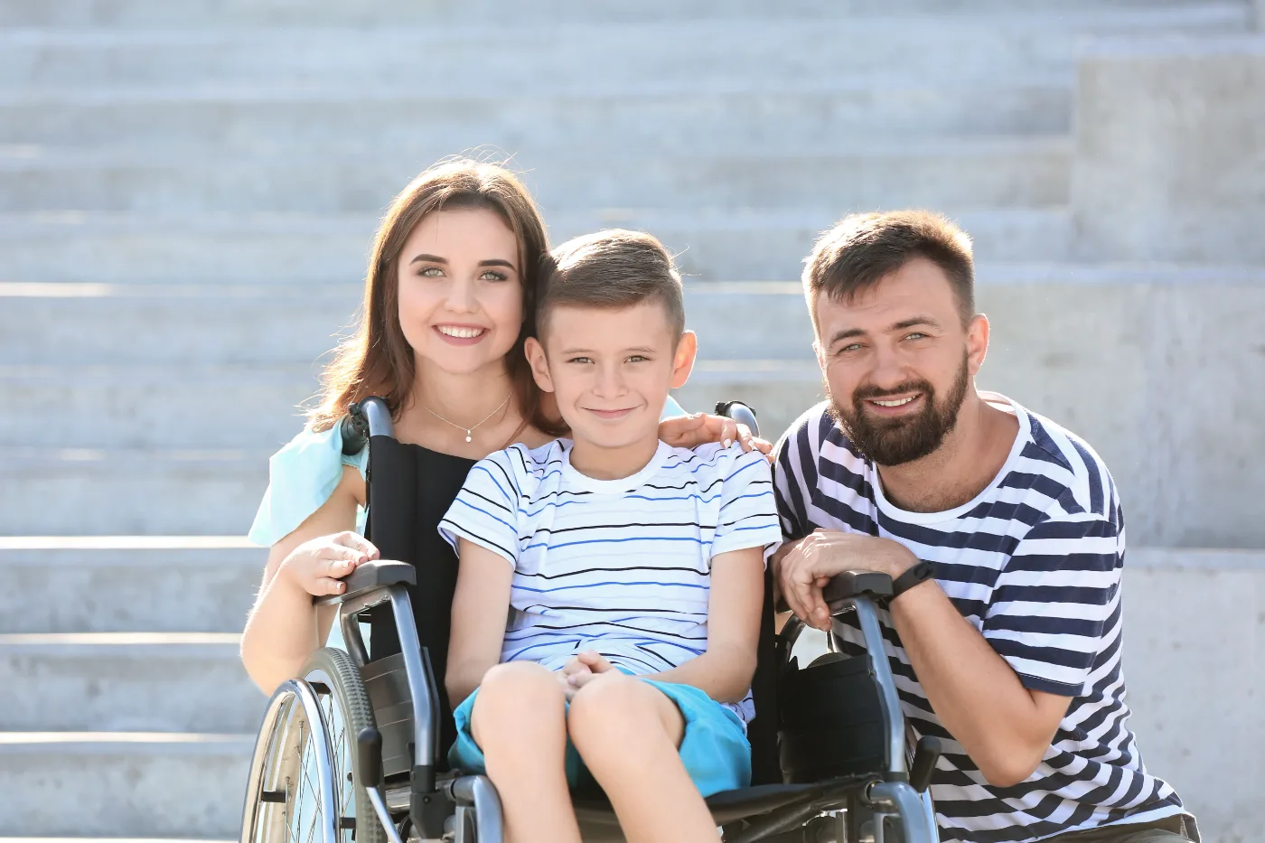 A family outdoors with their son who uses a wheelchair